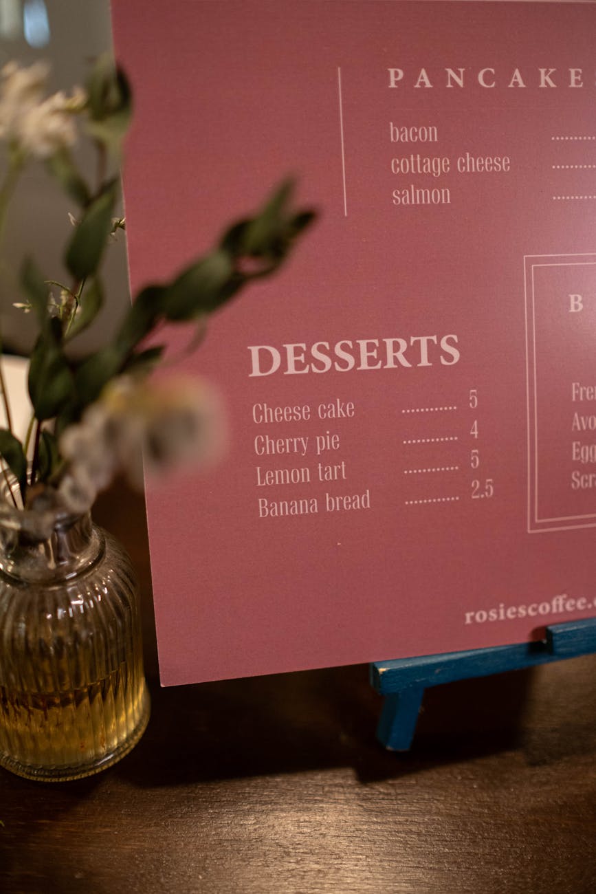 A styled cafe menu next to a decorative vase.