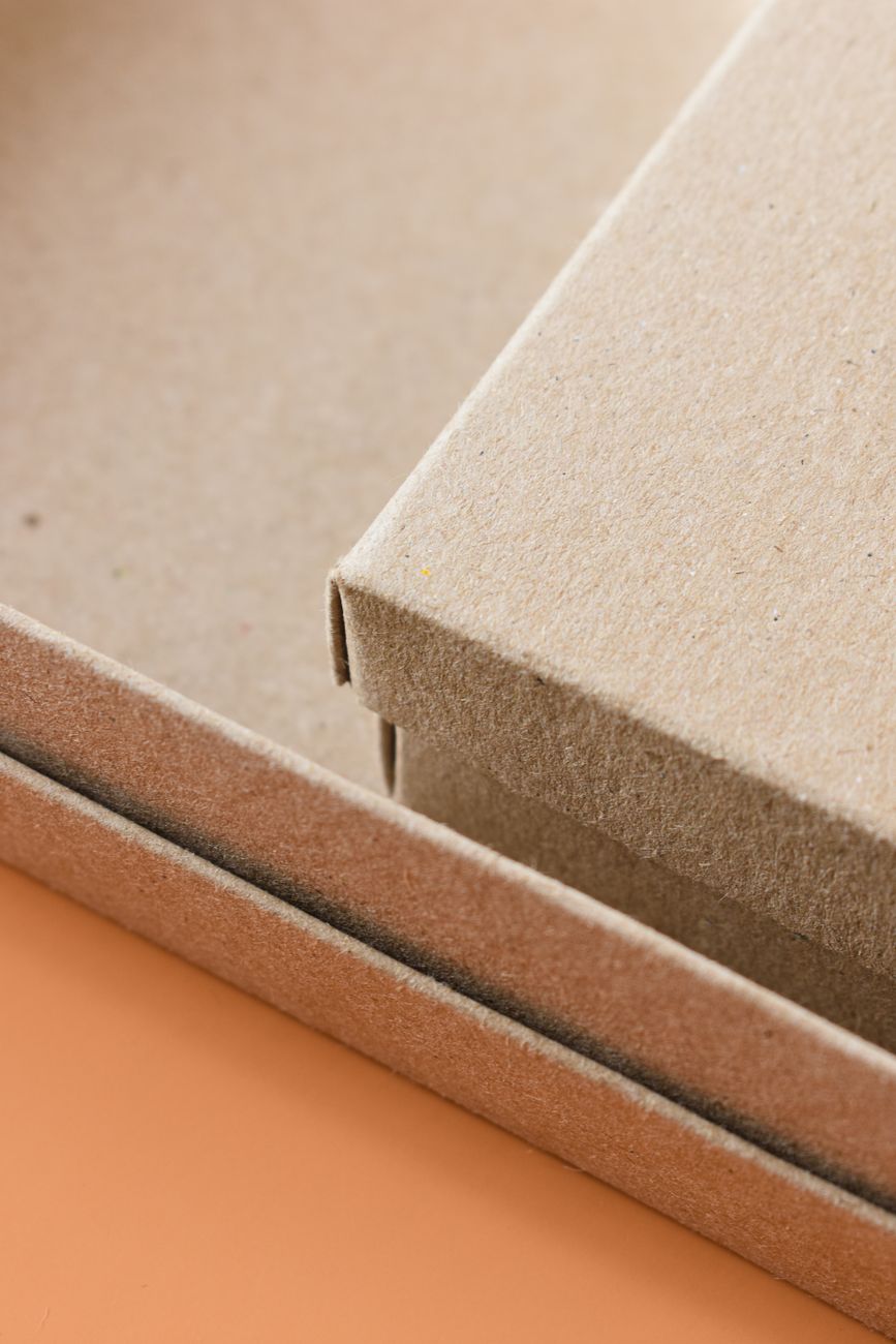 Eco-friendly cardboard packaging boxes on an orange background.